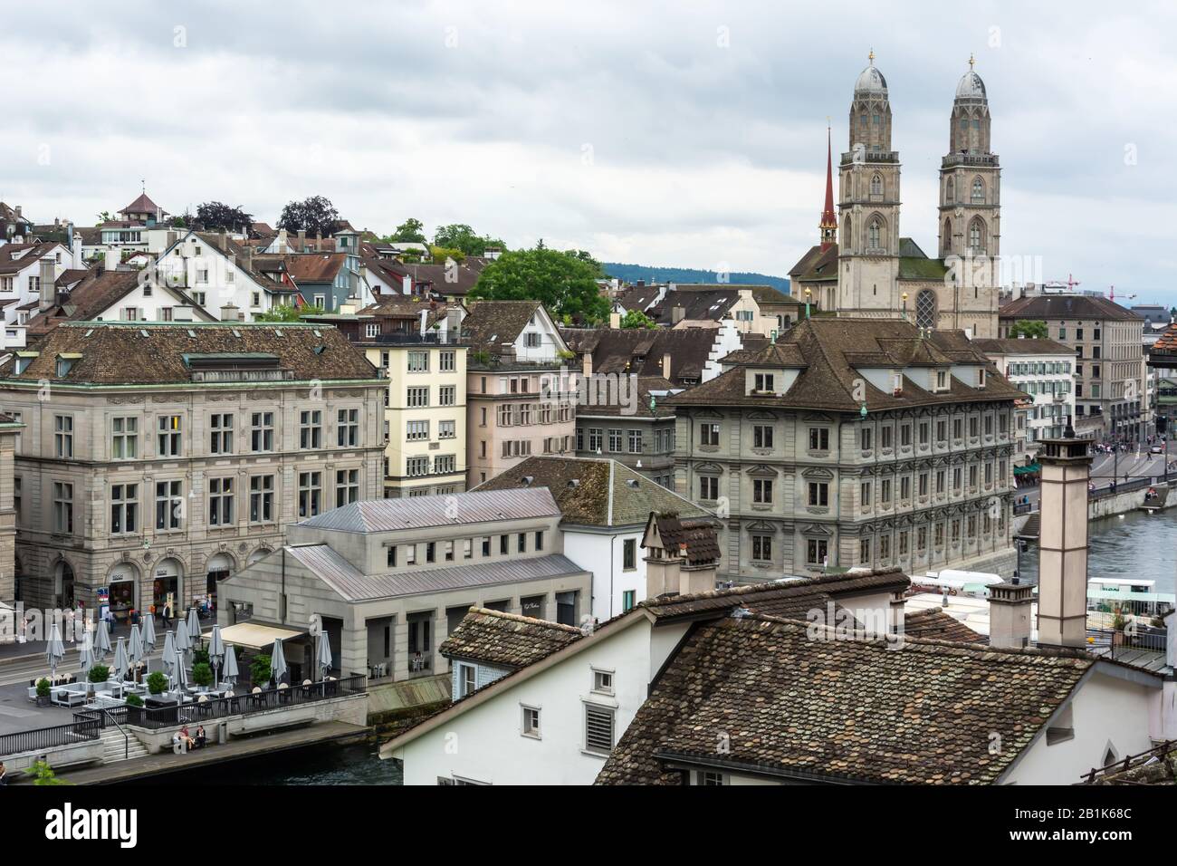 Zurigo, Svizzera – 25 Giugno 2016. Vista sul centro di Zurigo verso la chiesa Grossmunster, con proprietà commerciali e persone. Foto Stock