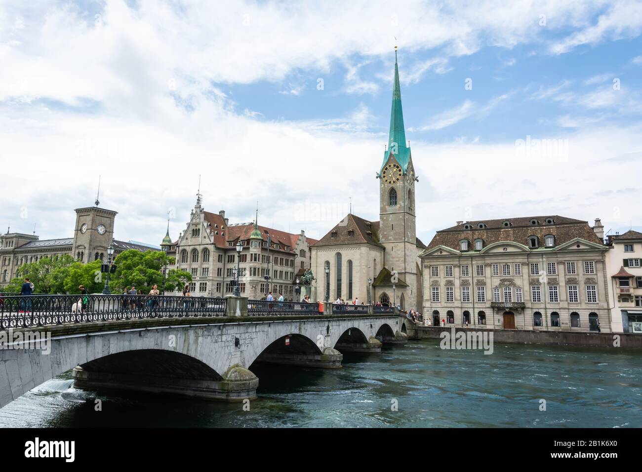 Zurigo, Svizzera – 25 Giugno 2016. Vista sul ponte Munsterbrucke e sulla chiesa Fraumunster di Zurigo, con edifici storici e persone circostanti. Foto Stock