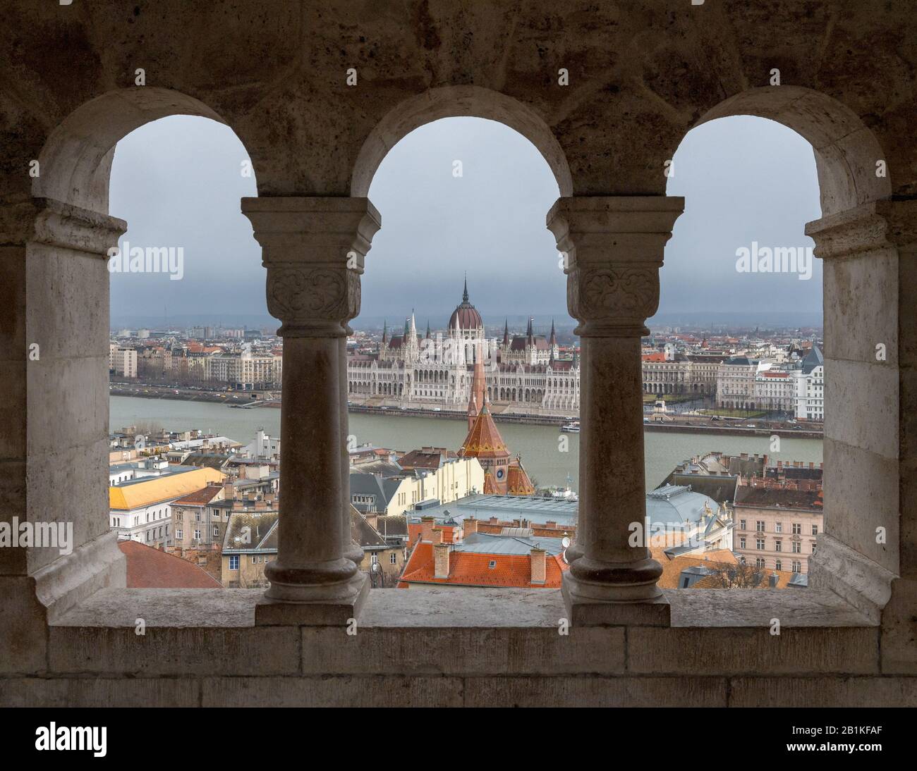 Palazzo del Parlamento ungherese visto attraverso i portici del bastione dei pescatori sulla collina del Castello di Buda, Budapest con Foto Stock