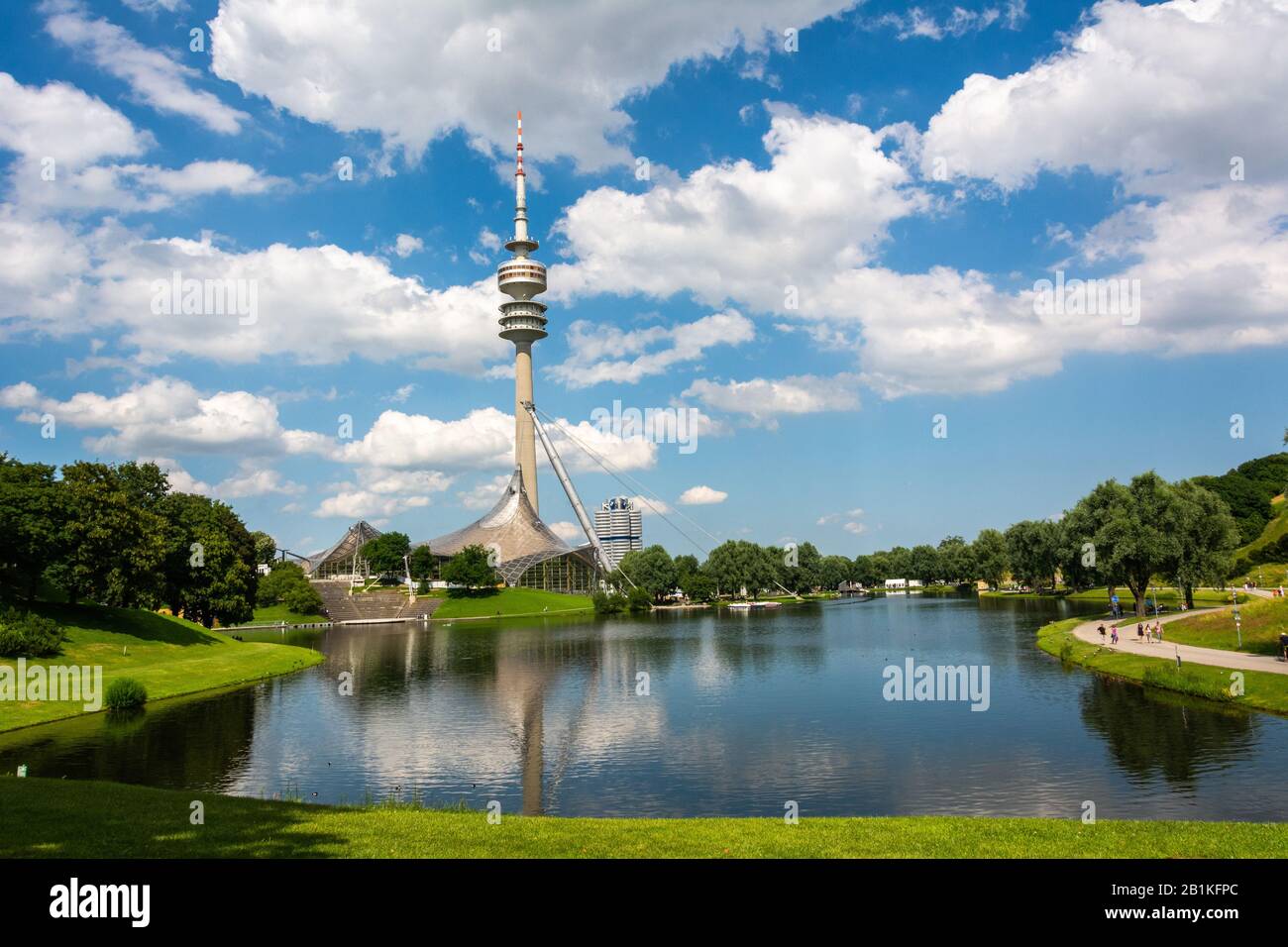 Monaco Di Baviera, Germania – 1° Luglio 2016. Vista della Torre olimpica (Olympiaturm) attraverso lo stagno olimpico nel parco olimpico di Monaco, Germania, in una soleggiata giornata estiva, Foto Stock