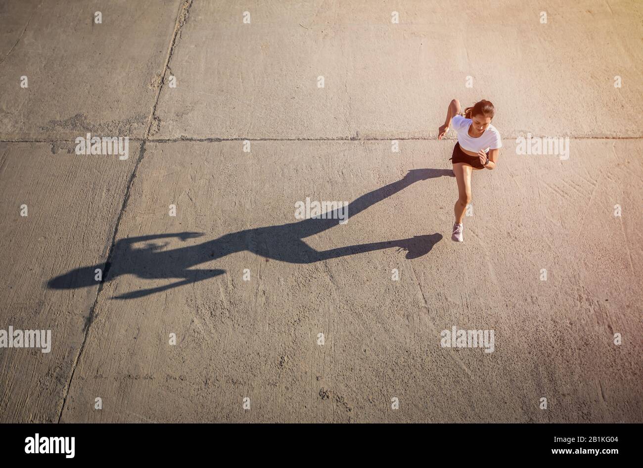 Vista dall'alto di Asian Woman che si sprint e corridore lavorando fuori nella strada della città Foto Stock