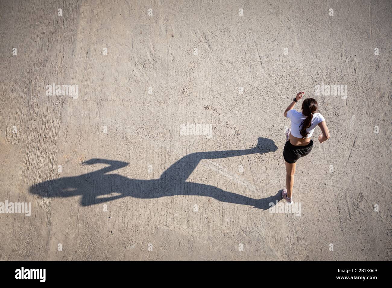 Vista dall'alto di Asian Woman che si sprint e corridore lavorando fuori nella strada della città Foto Stock