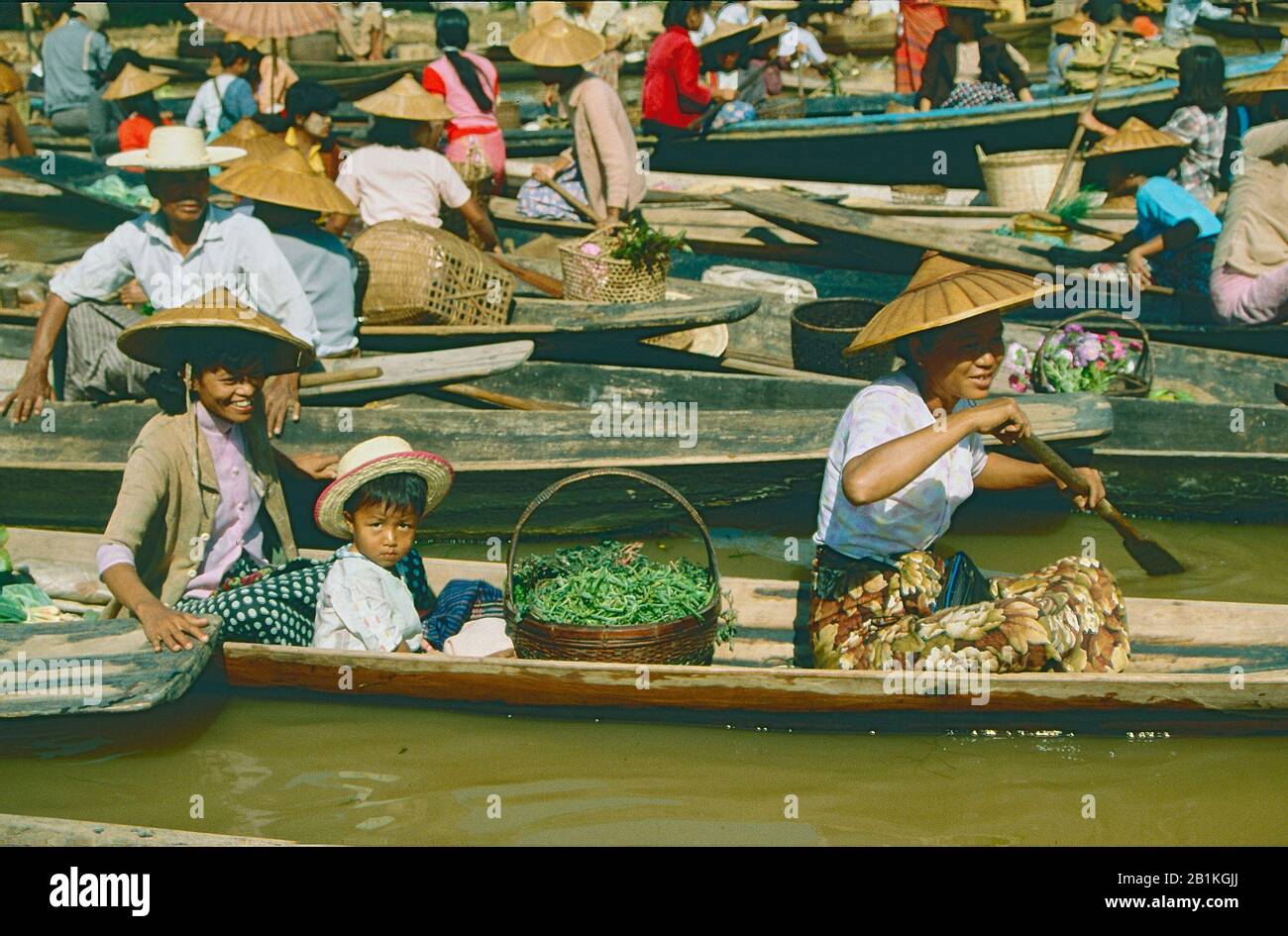 Donne in canoe di legno che vendono frutta e verdura in un mercato galleggiante a Ywama sul Lago Inle, Myanmar. Foto Stock