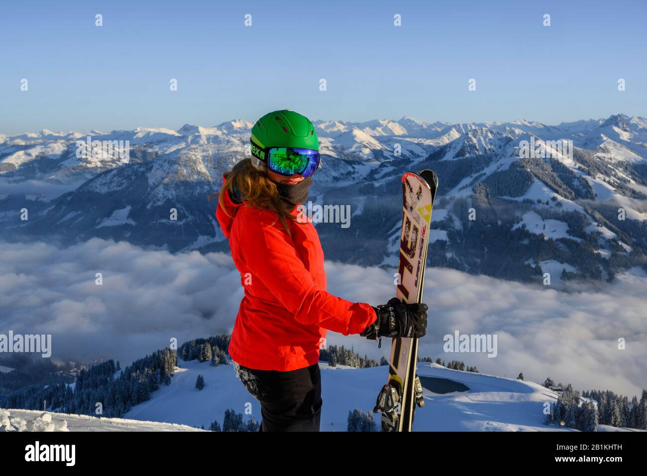 Sciatore con casco da sci e ski stand di fronte al panorama montano, guarda la macchina fotografica, SkiWelt Wilder Kaiser, Bressanone im Thale, Tirolo, Austria Foto Stock