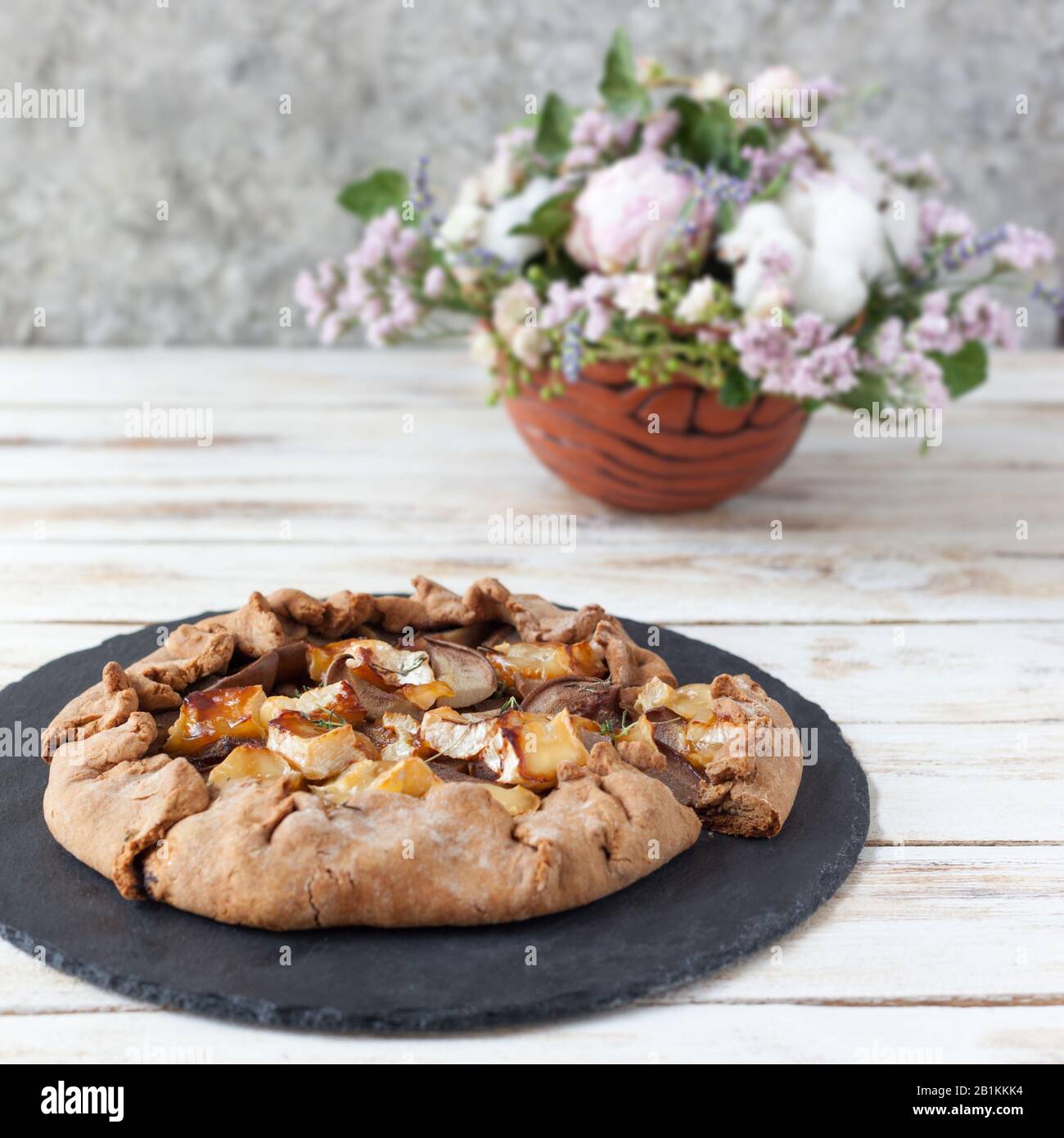 Galette con pere e formaggio Brie. Chiamata anche galette bretone, galette des Rois, Galeta. Cucina francese. Su vecchio sfondo bianco di legno. Foto Stock