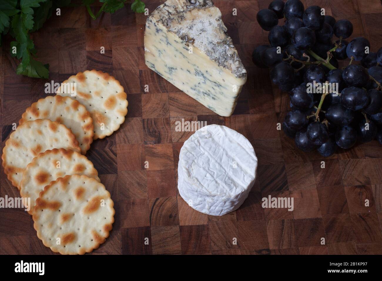 Una selezione di formaggi, uva, cracker e coriandolo fresco Foto Stock