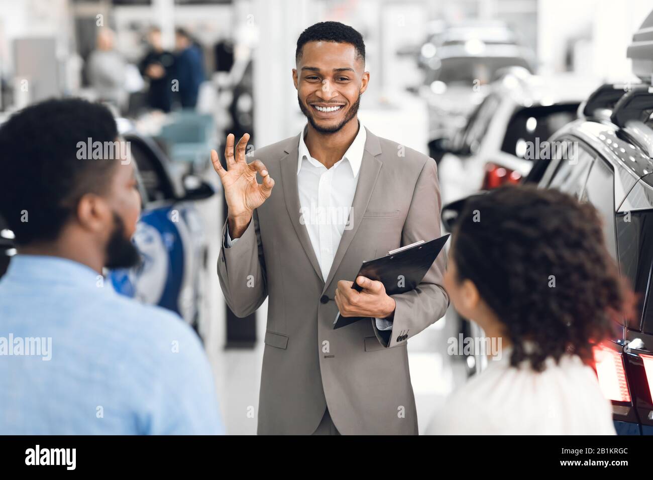 Concessionario Auto Gesturing Okay Parlando Con I Clienti In Dealership Store Foto Stock