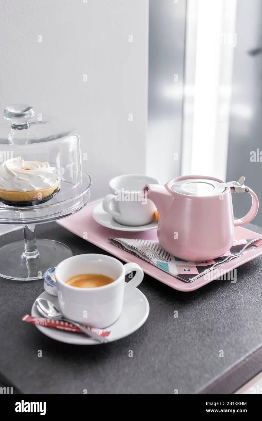 Budapest, Ungheria - 18 aprile 2019: Piatto da caffè e tazze da preparare su un vassoio e torta da dessert in un ambiente luminoso e chiaro. Foto Stock