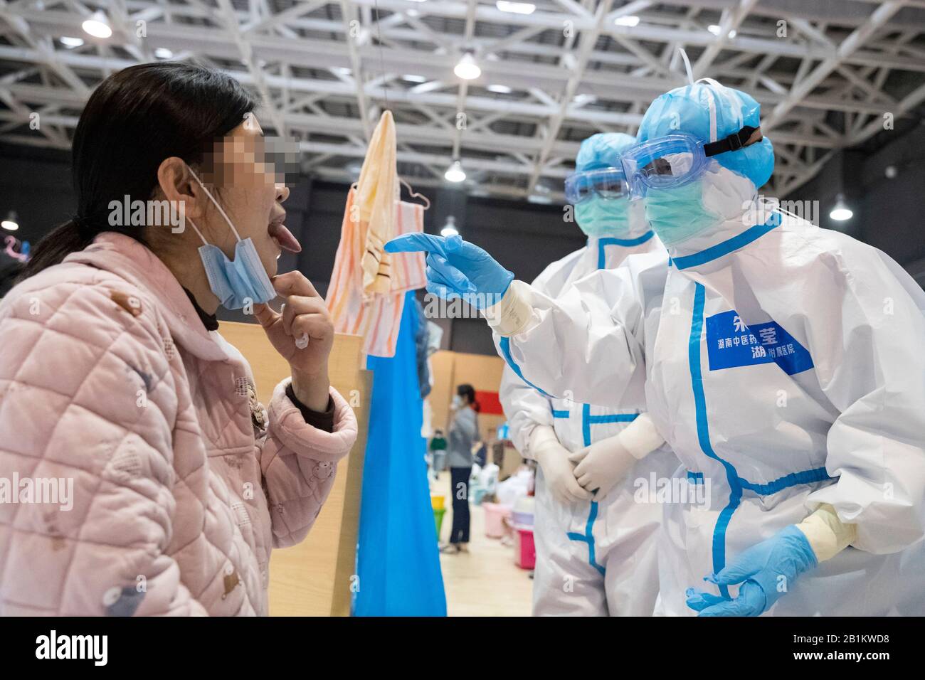 (200226) -- WUHAN, 26 febbraio 2020 (Xinhua) -- gli operatori sanitari trattano un paziente con terapie tradizionali di medicina cinese (TCM) in un ospedale temporaneo nel distretto di Jiangxia a Wuhan, nella provincia centrale cinese di Hubei, 25 febbraio 2020. Il primo lotto di 23 pazienti è uscito dal primo ospedale temporaneo con la medicina cinese tradizionale (TCM) Mercoledì a Wuhan, l'epicentro del focolaio di coronavirus nella provincia centrale cinese di Hubei. L'ospedale Make-shift nel distretto di Jiangxia di Wuhan è stato trasformato da un centro sportivo. Personale medico di 20 ospedali TCM di cinque province anche Foto Stock
