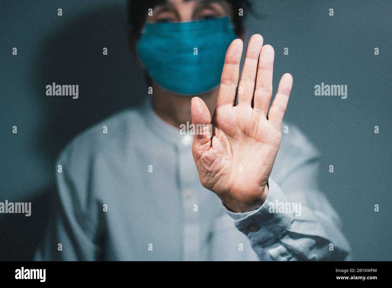Arrestare la quarantena del coronavirus e il concetto di inquinamento atmosferico pm2.5. Donna anziana malata che indossa maschera respiratore per proteggere con braccio allungato. Wuhan, Cina ep Foto Stock