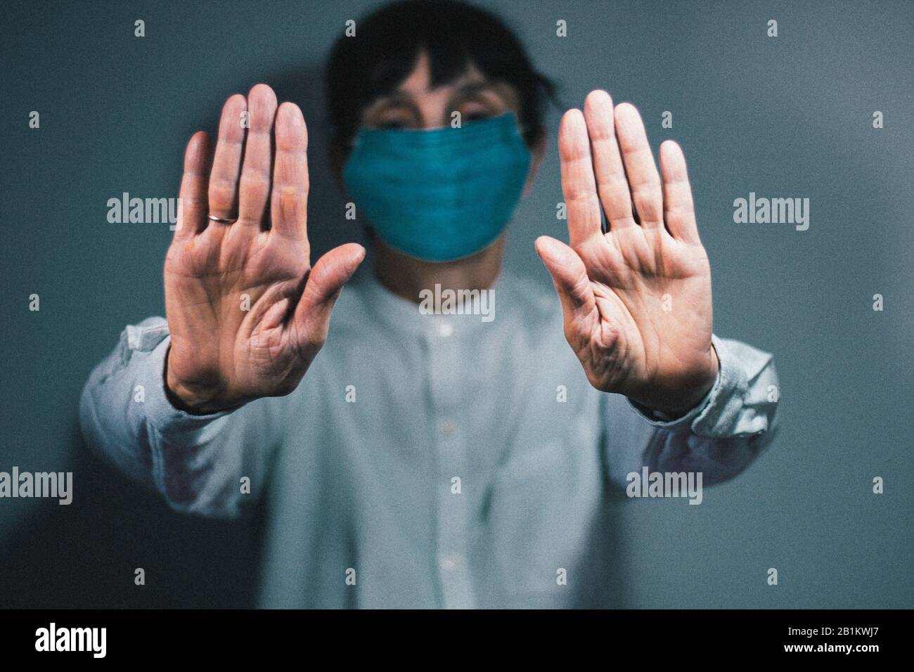 Arrestare la quarantena del coronavirus e il concetto di inquinamento atmosferico pm2.5. Donna anziana malata che indossa maschera respiratore per proteggere con braccio allungato. Wuhan, Cina ep Foto Stock