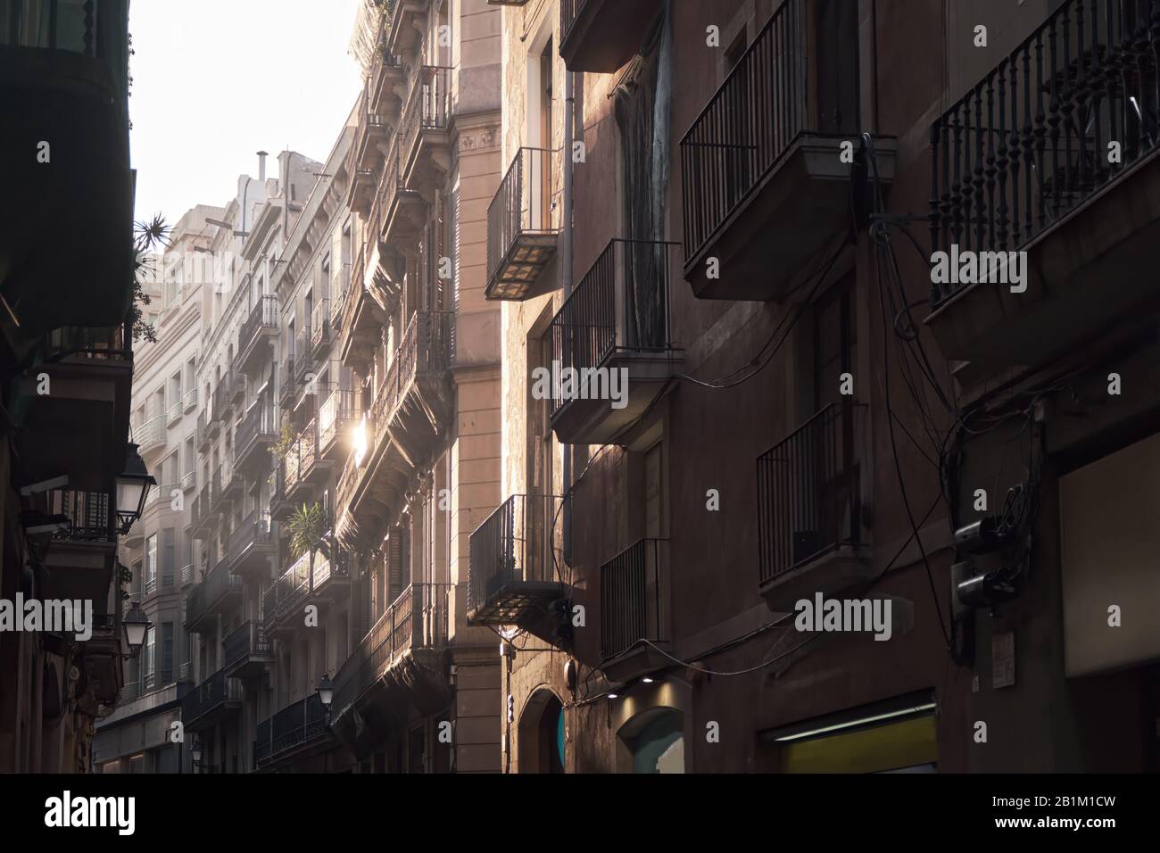 Strada stretta illuminata lateralmente dal tramonto, Barcellona Foto Stock