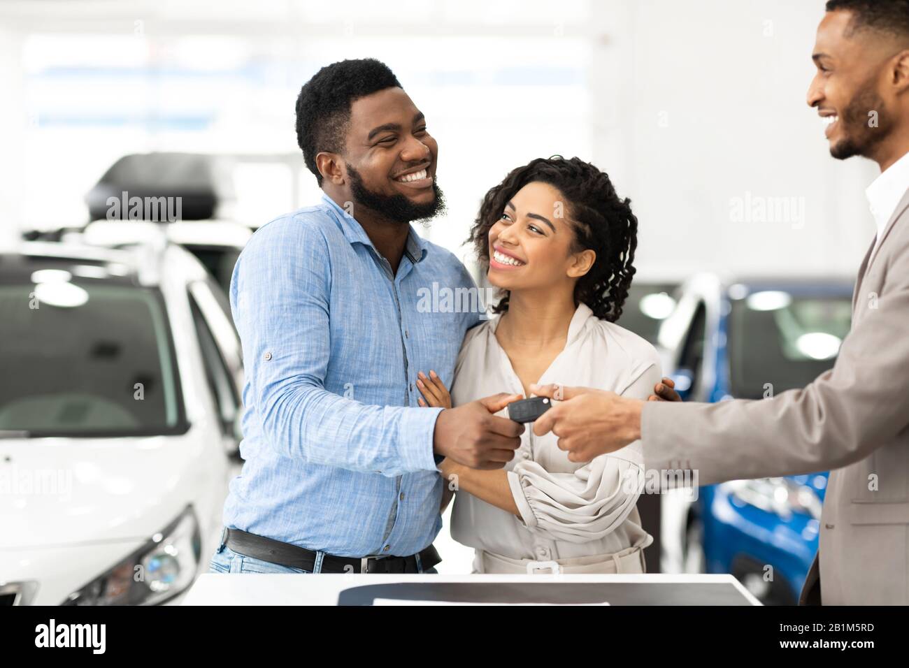 Manager Che Fornisce Auto Key A Family Couple Nel Dealership Shop Foto Stock