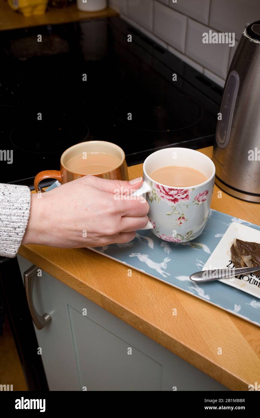 giovani donne che prendono la sua tazza di tè dal countertop Foto Stock