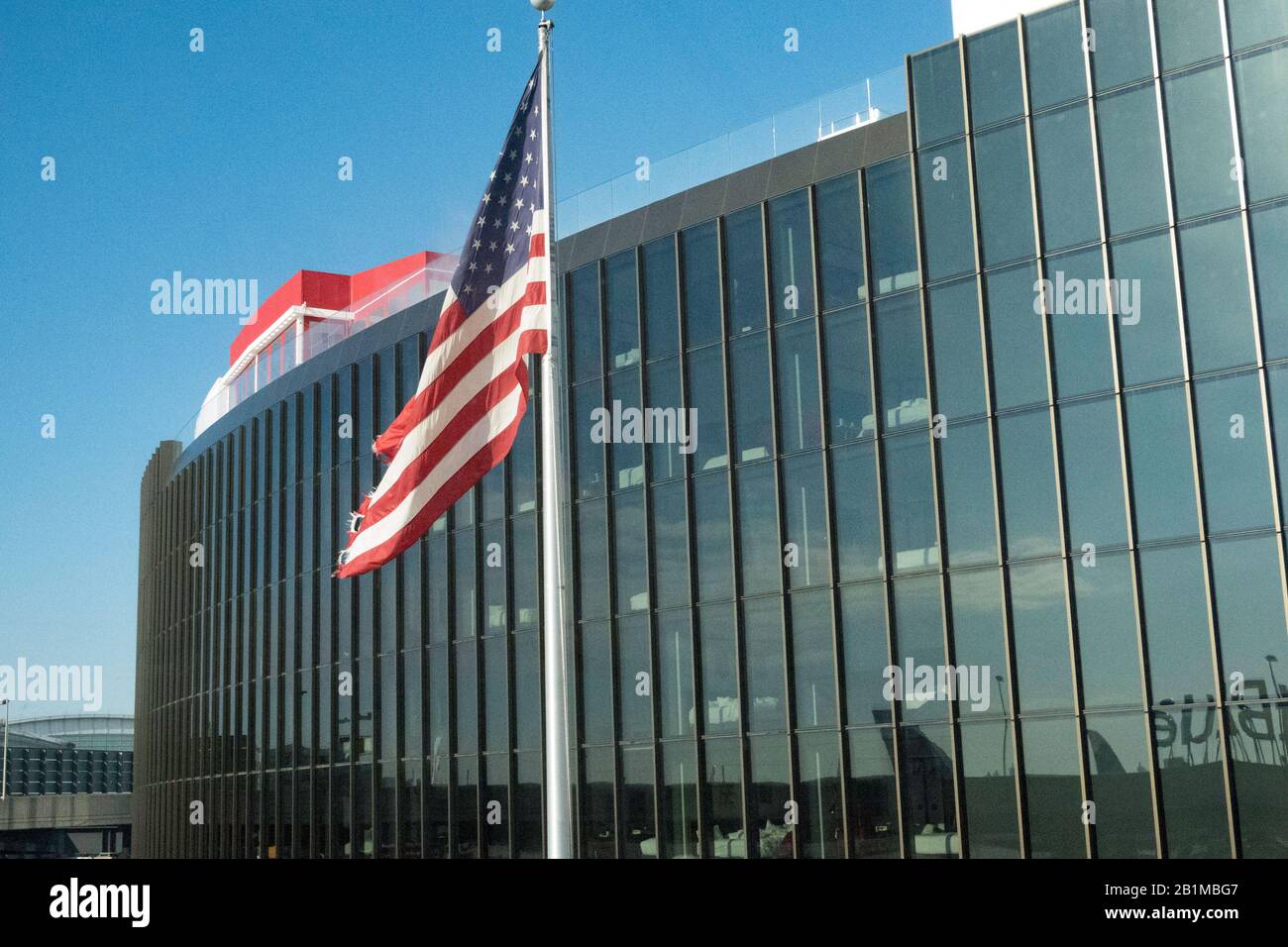 Bandiera vola di fronte ad un'ala dell'Hotel TWA all'Aeroporto JFK di New York, Stati Uniti Foto Stock