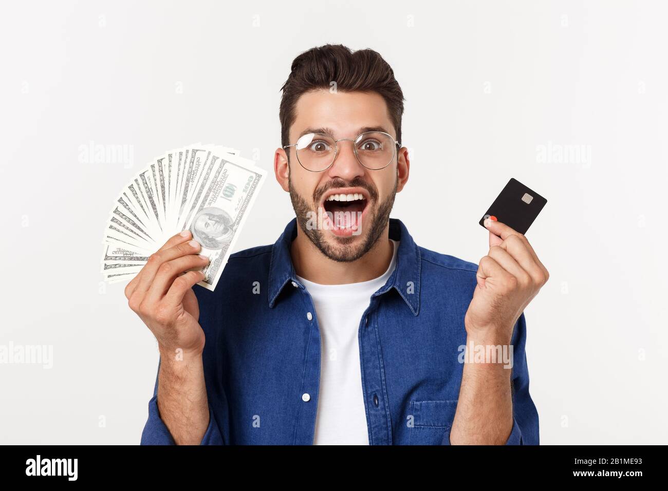 Ritratto di un uomo frinedly bearded che tiene la carta di credito e che mostra i contanti isolati su sfondo bianco Foto Stock