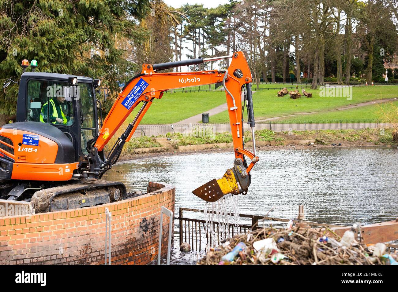 Operaio di manutenzione che opera un digger JCB a Wardown Park, Luton, Bedfordshire, Regno Unito Foto Stock