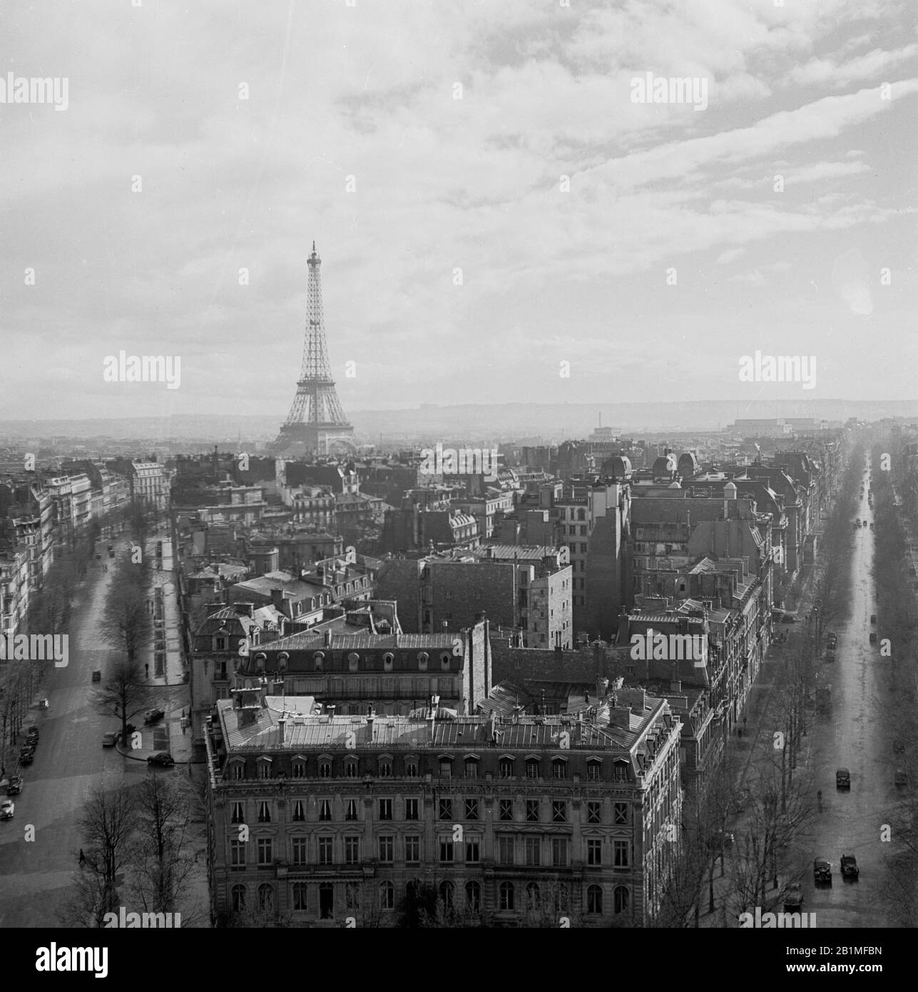 1950s, vista storica e aerea sullo skyline di Parigi, con il famoso punto di riferimento parigino, la Torre Eiffel sul Champ de Mars in lontananza. Costruita nel 1889 per la Fiera del mondo, la torre in ferro battuto è una struttura iconica della città e considerata una meraviglia architettonica. Foto Stock