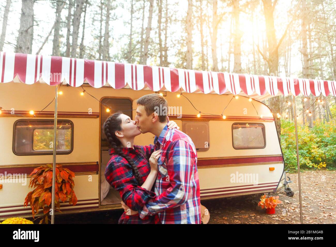 Ritratto di coppia romantica l uomo e la donna sorridente mentre abbracciando vicino casa su ruote all'esterno Foto Stock