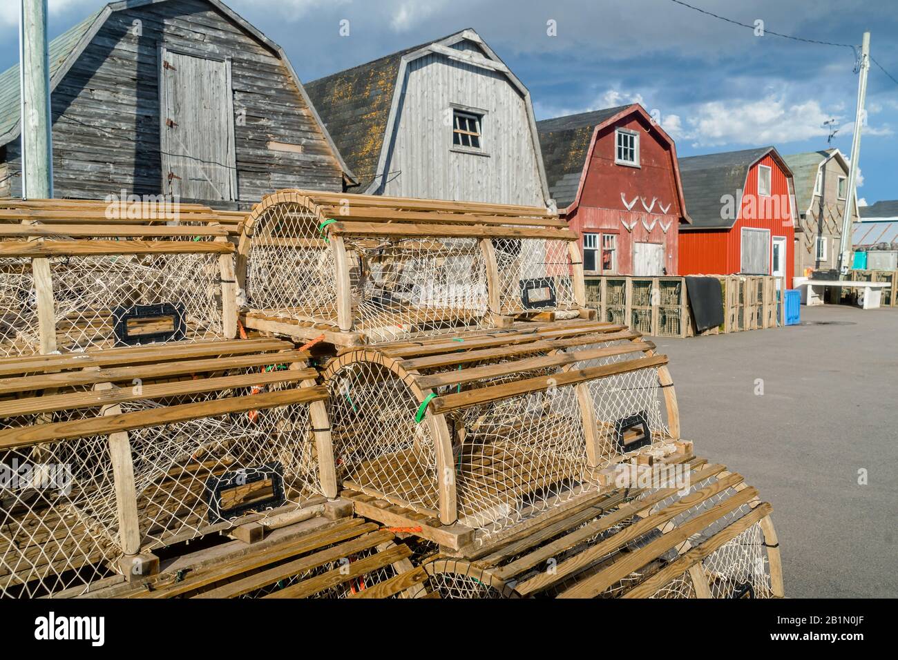 Trappole di aragosta accatastate contro i capannoni di esche su un molo nella rurale Prince Edward Island, Canada, Foto Stock