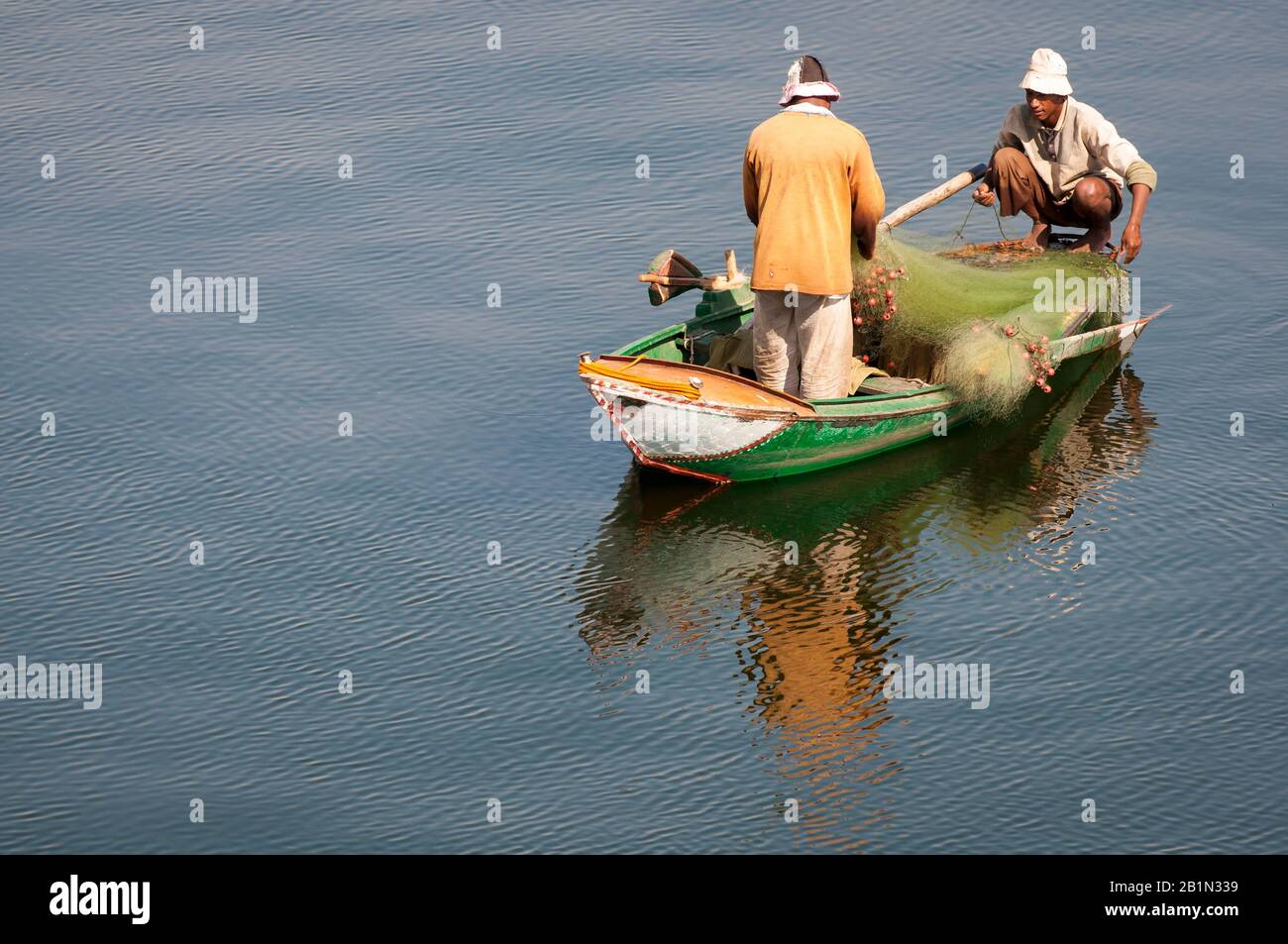 Assuan, EGITTO - 6 NOVEMBRE 2010: Un paio di uomini egiziani equilibrio su una piccola barca tradizionale con attrezzature da pesca sul fiume Nilo. Foto Stock