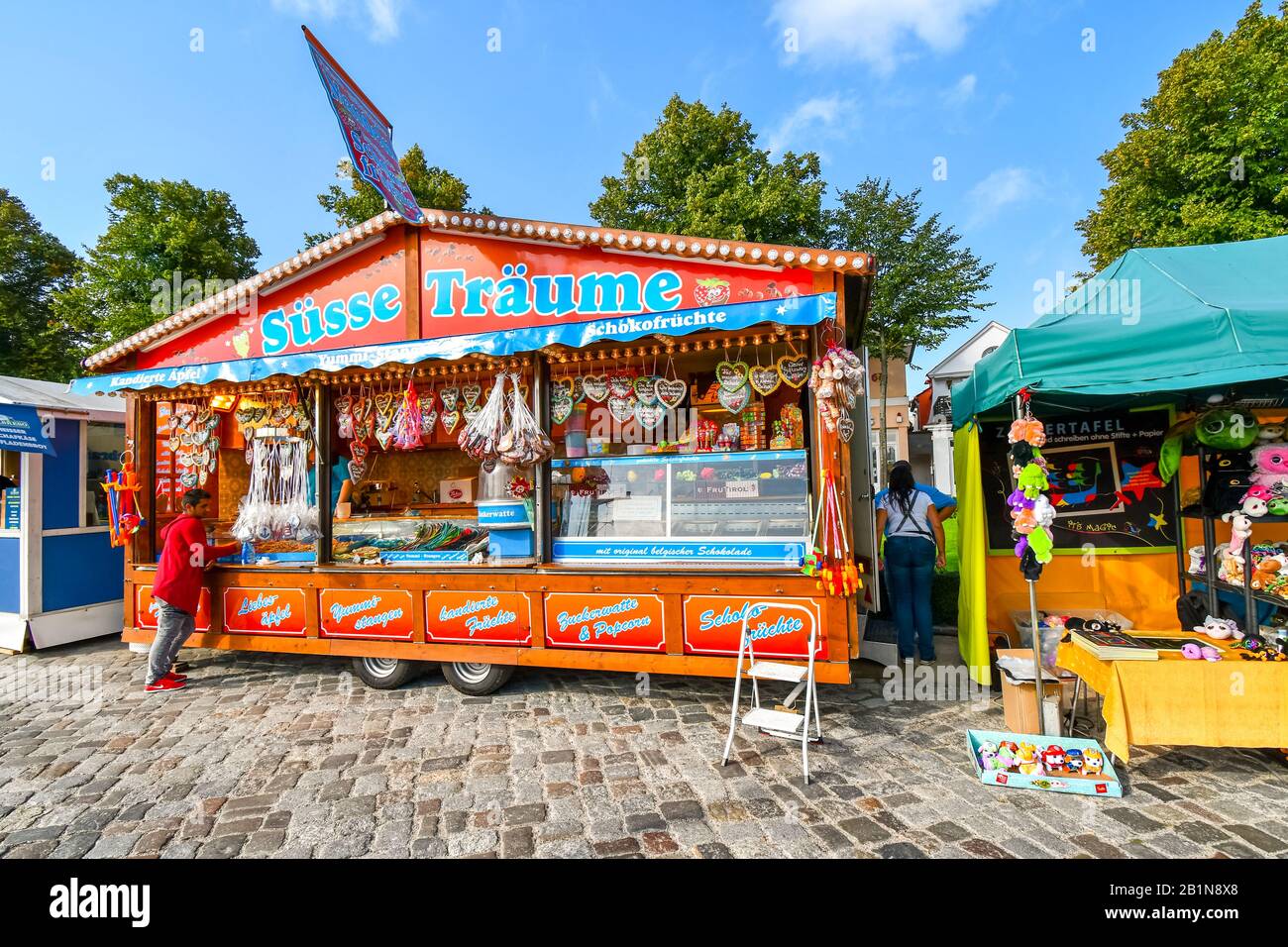 Un cliente ordina da un fornitore colorato di strada sulla passeggiata lungomare del lungomare di Strand a Warnemunde, Germania. Foto Stock