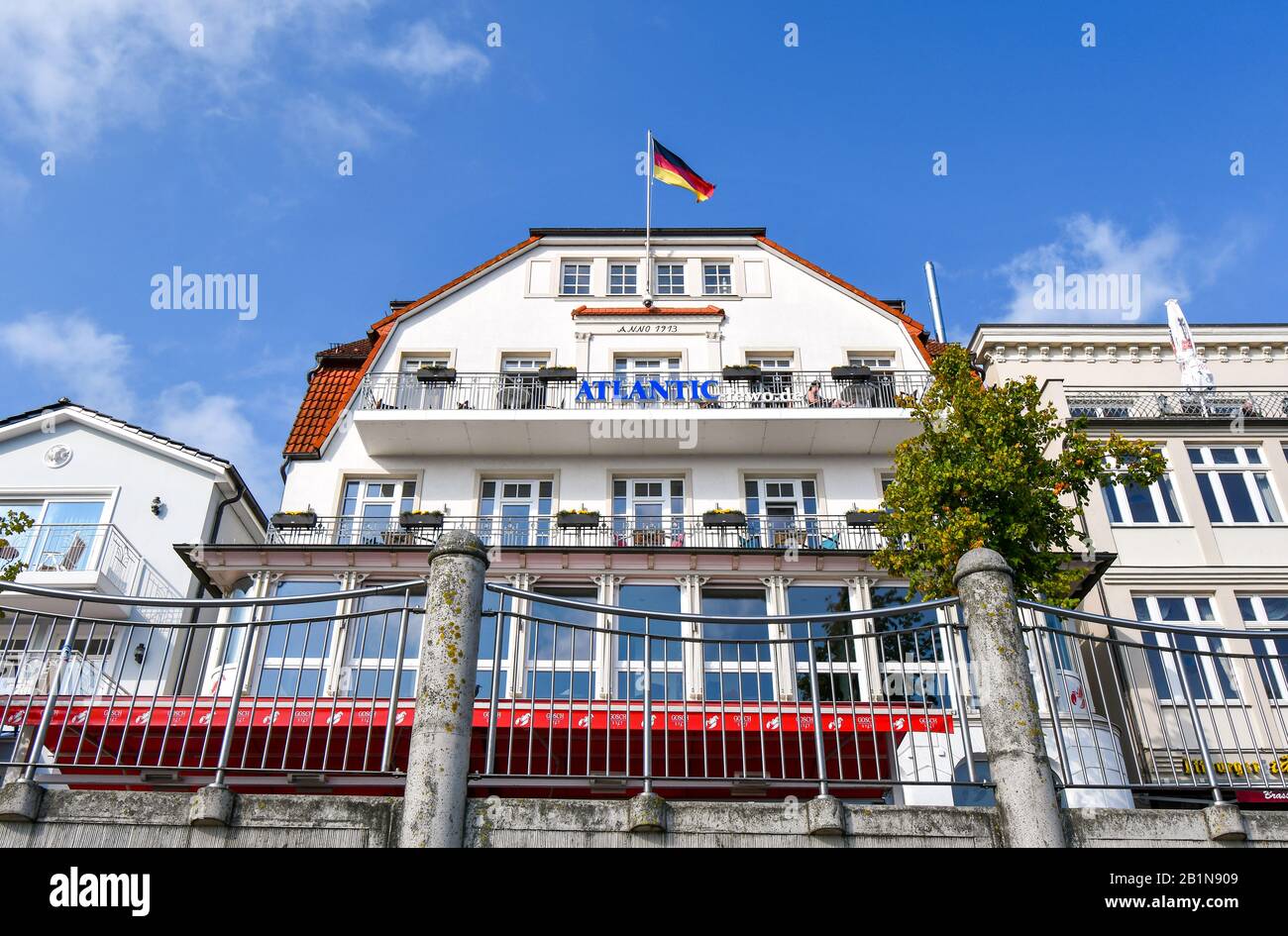 Vista dal lungomare dell'Atlantic Hotel con una bandiera tedesca che vola a Warnemunde Rostock Germania in una giornata di sole. Foto Stock