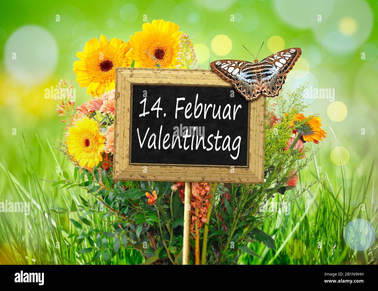 Piccola lavagna con una farfalla contro un prato fiori lettere 14 FEBBRAIO VALENTINSTAG (San Valentino) Foto Stock