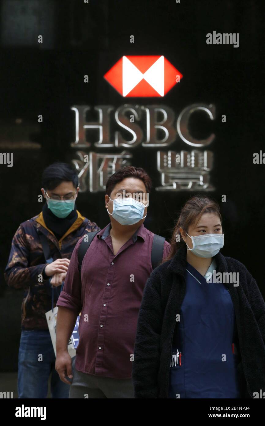 Hong Kong, HONG KONG. 27th Feb, 2020. Persone mostrate di fronte ad un ramo HSBC che indossano maschere per proteggersi dal Coronavirus (Covid-19) a Hong Kong. Si ritiene che il virus sia iniziato in un mercato animale vivo a Wuhan, in Cina. Credit: David Mcintyre/Zuma Wire/Alamy Live News Foto Stock