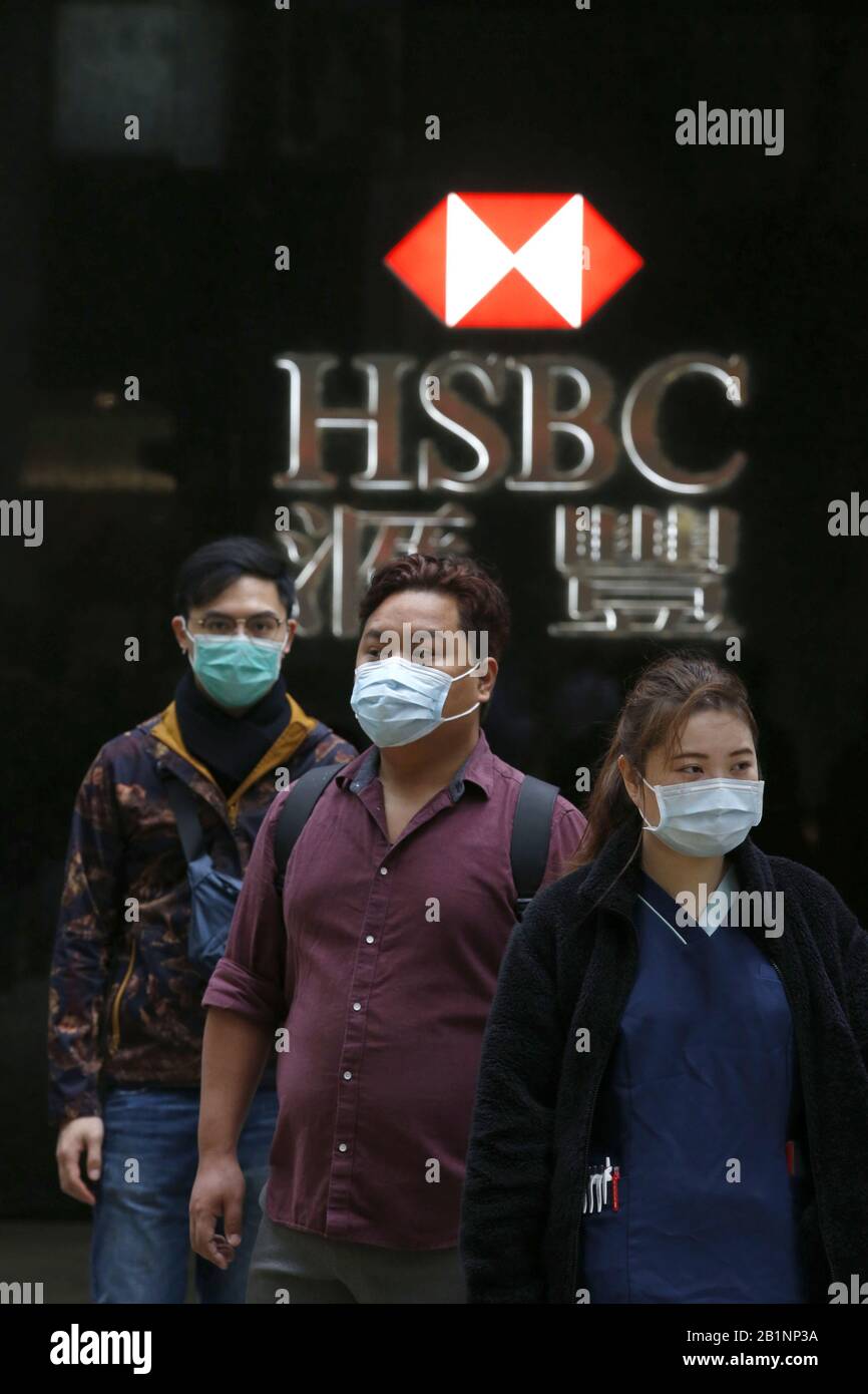 Hong Kong, HONG KONG. 27th Feb, 2020. Persone mostrate di fronte ad un ramo HSBC che indossano maschere per proteggersi dal Coronavirus (Covid-19) a Hong Kong. Si ritiene che il virus sia iniziato in un mercato animale vivo a Wuhan, in Cina. Credit: David Mcintyre/Zuma Wire/Alamy Live News Foto Stock