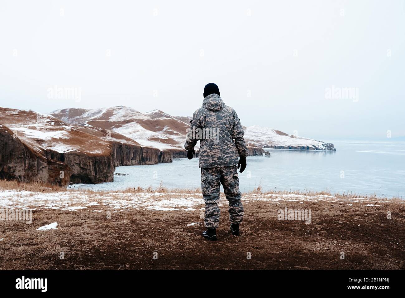 uomo in abbigliamento militare mimetizzato sullo sfondo di un paesaggio  invernale e di pura neve bianca, un cacciatore si leva in piedi sul  sorprendente paesaggio settentrionale Foto stock - Alamy