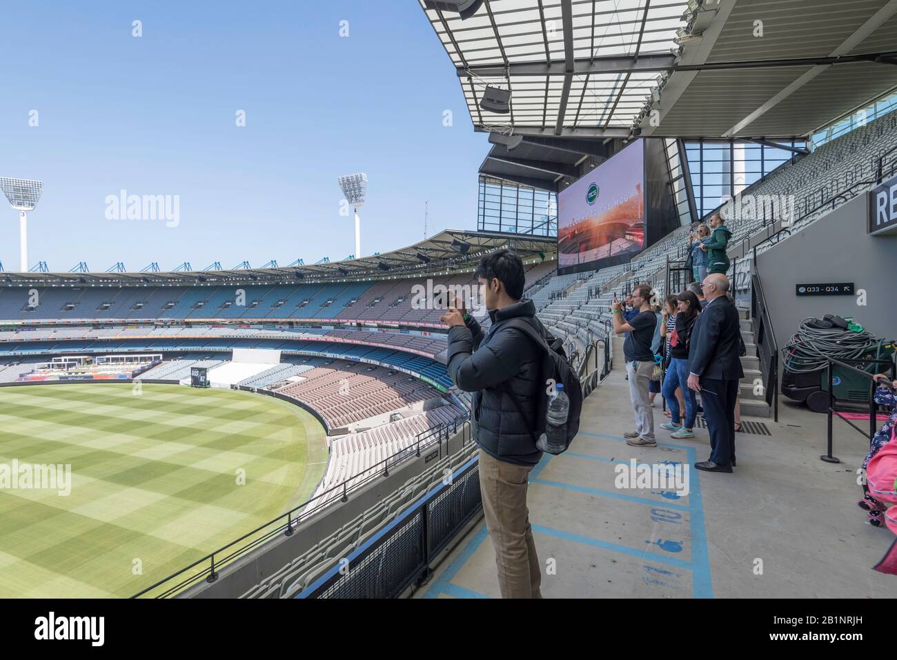 Un uomo usa il suo telefono per fotografare il campo Di Melbourne Cricket Ground (MCG) in Australia durante un tour dello stadio Foto Stock