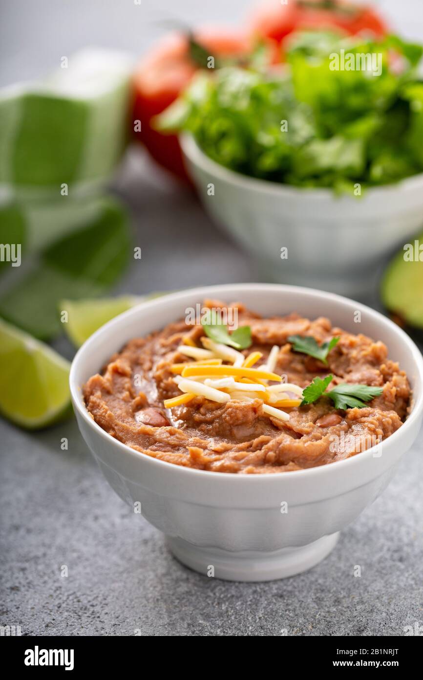 Fagioli refriged in una ciotola bianca Foto Stock