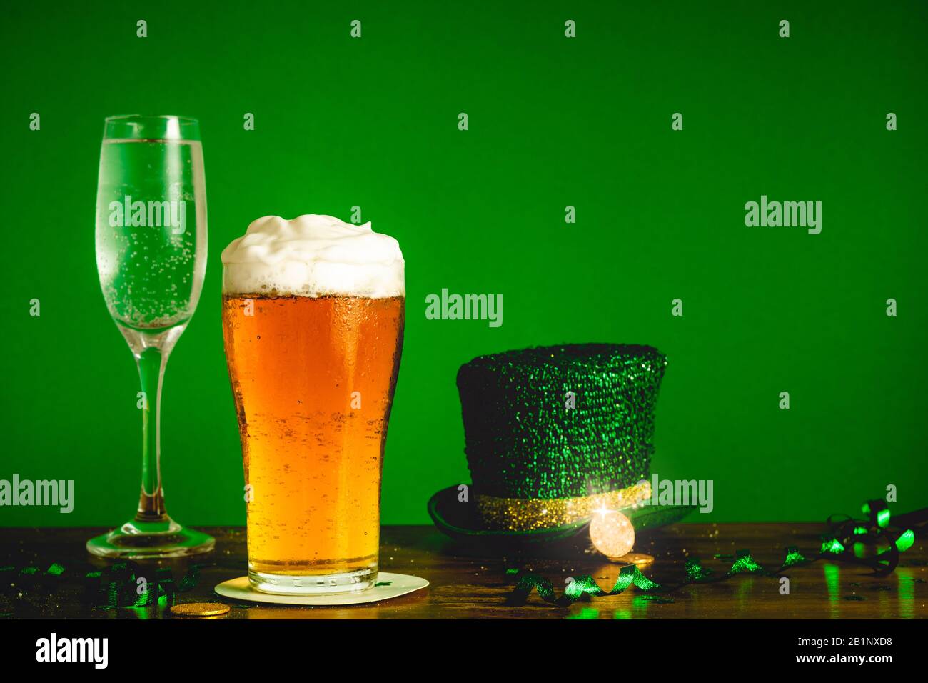 Concetto di festa di San Patrizio giorno con bicchiere di birra, champagne, cappello di leprechaun e monete d'oro sul tavolo - feste e celebrazioni conc Foto Stock