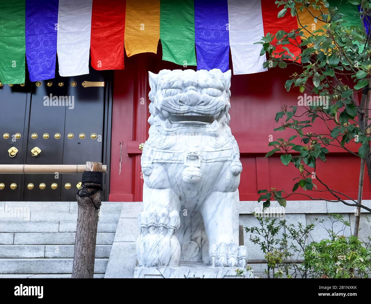 Tokyo, GIAPPONE - 20 APRILE 2018: Leoni di pietra e bandiere dai colori vivaci al santuario sensoji di tokyo Foto Stock