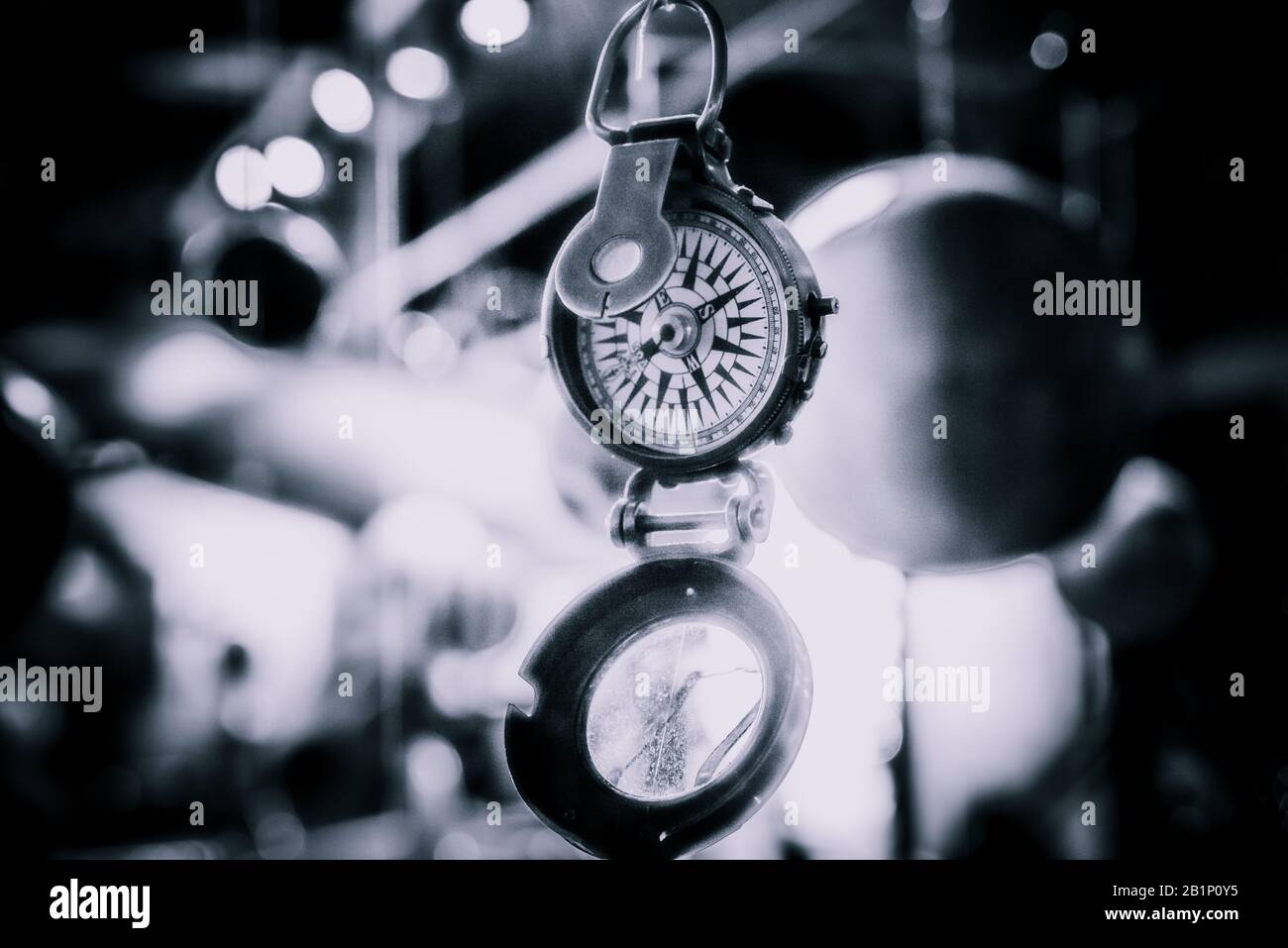 Bellissimo bokeh di fondo di una bussola appeso con luci e riflessioni in background. Concetto di essere perduti, libertà e ricerca della felicità. Foto Stock