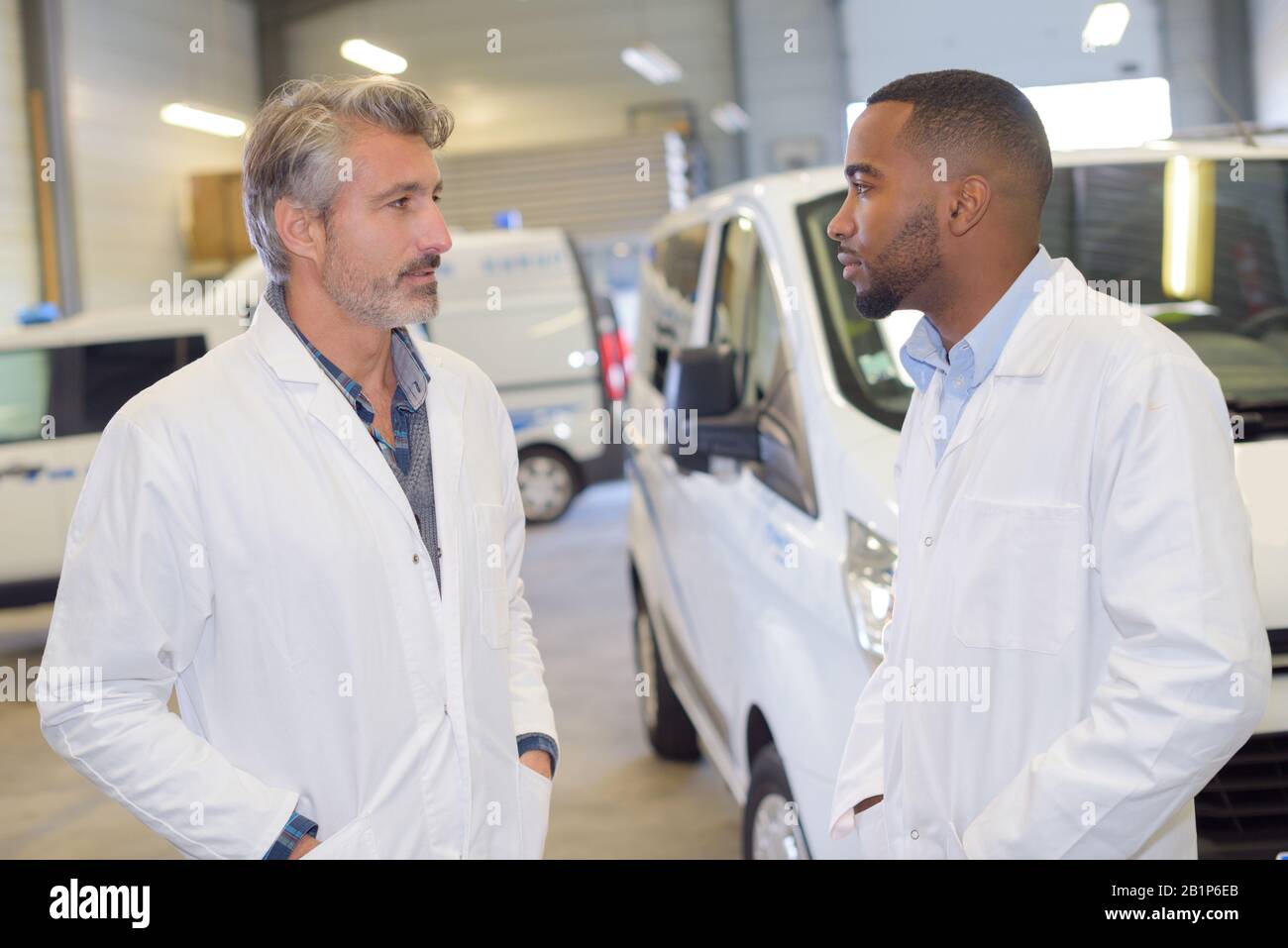 infermiere e medico che hanno una conversazione nel parcheggio dell'ambulanza Foto Stock