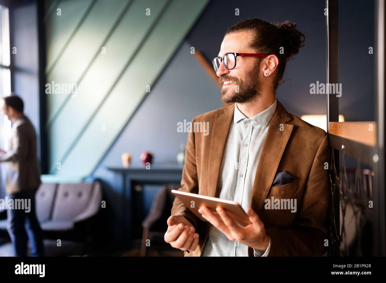 Ritratto di felice giovane business uomo esecutivo utilizzando tablet digitale Foto Stock