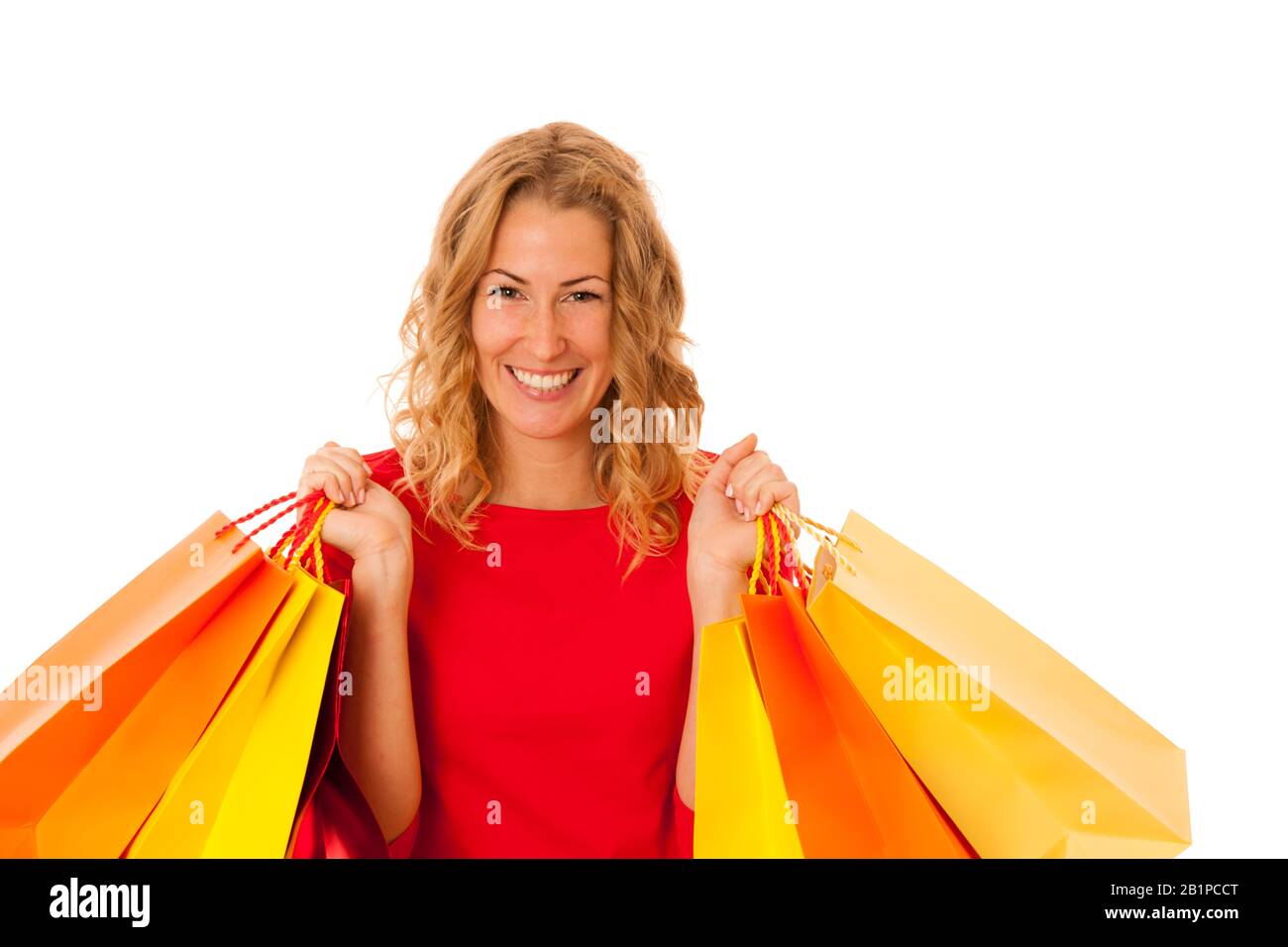 Cutwe brunette donna con capelli ricci marrone che tiene borse per lo shopping isolato su bianco Foto Stock