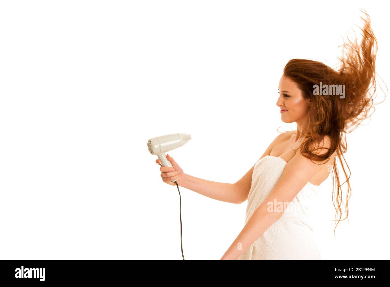 bella giovane donna asciuga i capelli con un soffiatore Foto Stock