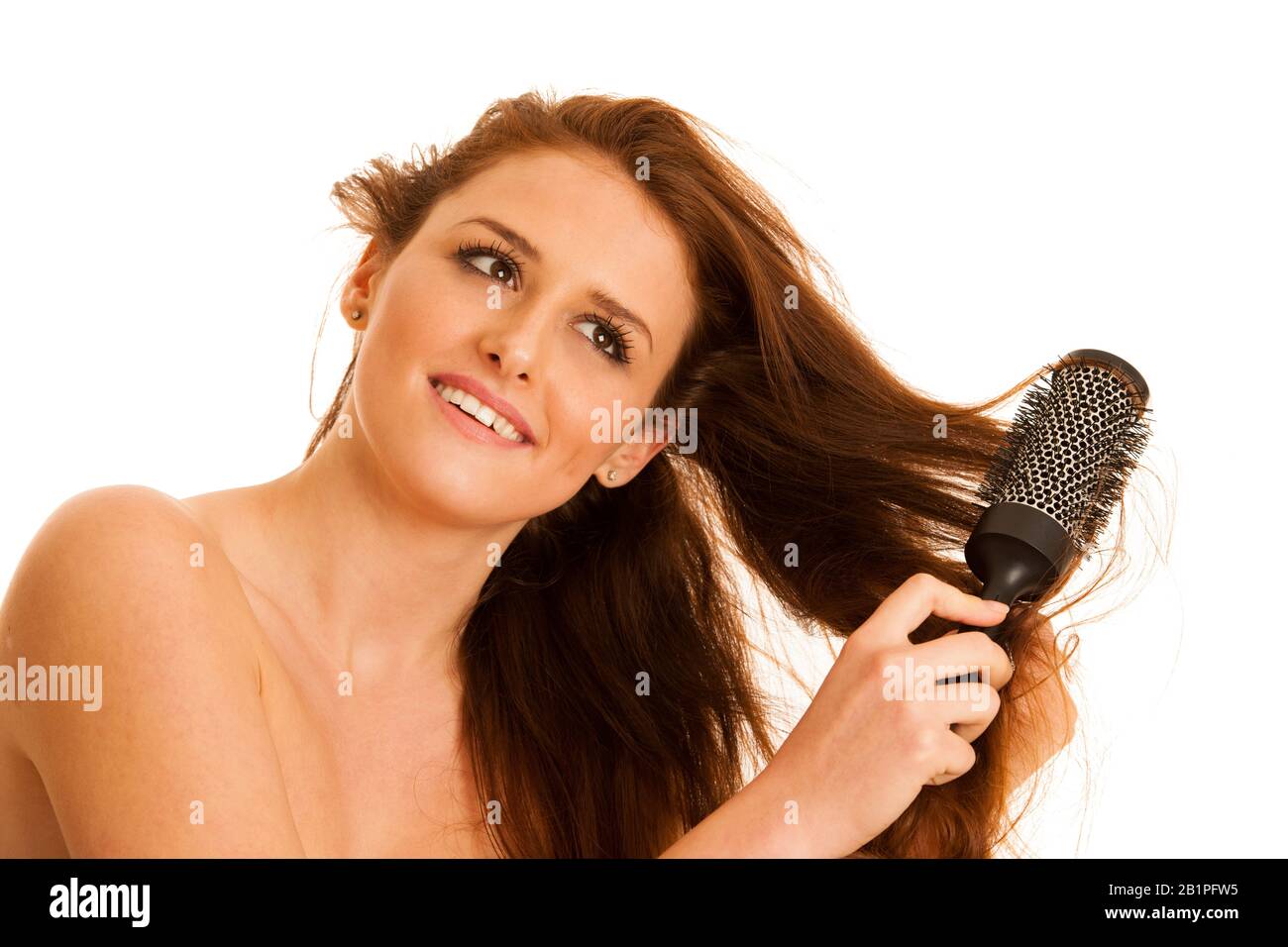 Bella giovane donna si pettina i capelli con una spazzola isolata su sfondo bianco Foto Stock