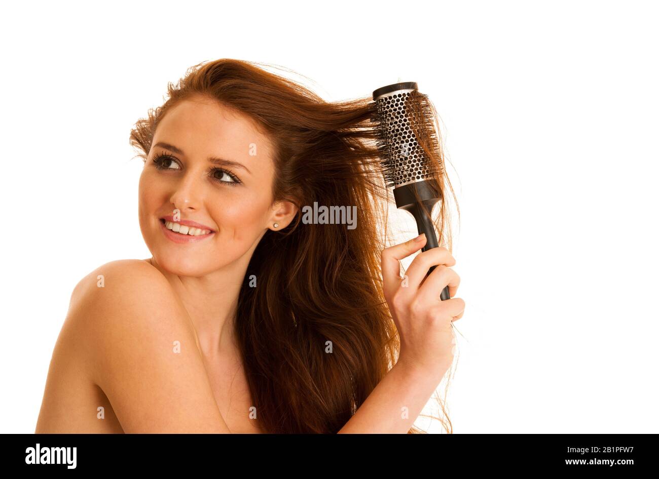 Bella giovane donna si pettina i capelli con una spazzola isolata su sfondo bianco Foto Stock