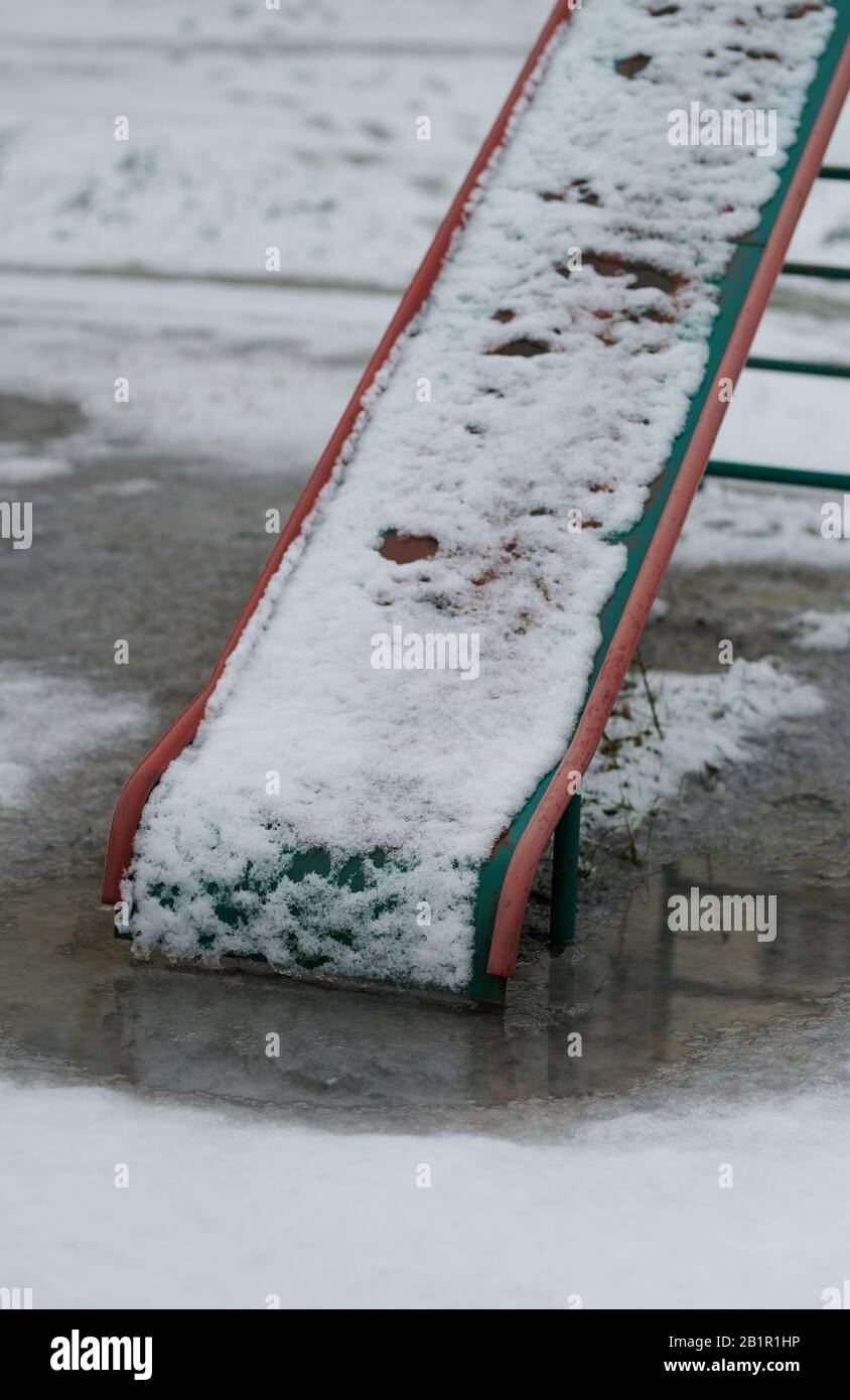 Tema del riscaldamento globale. Fusione di neve e acqua sul parco giochi per  bambini Foto stock - Alamy
