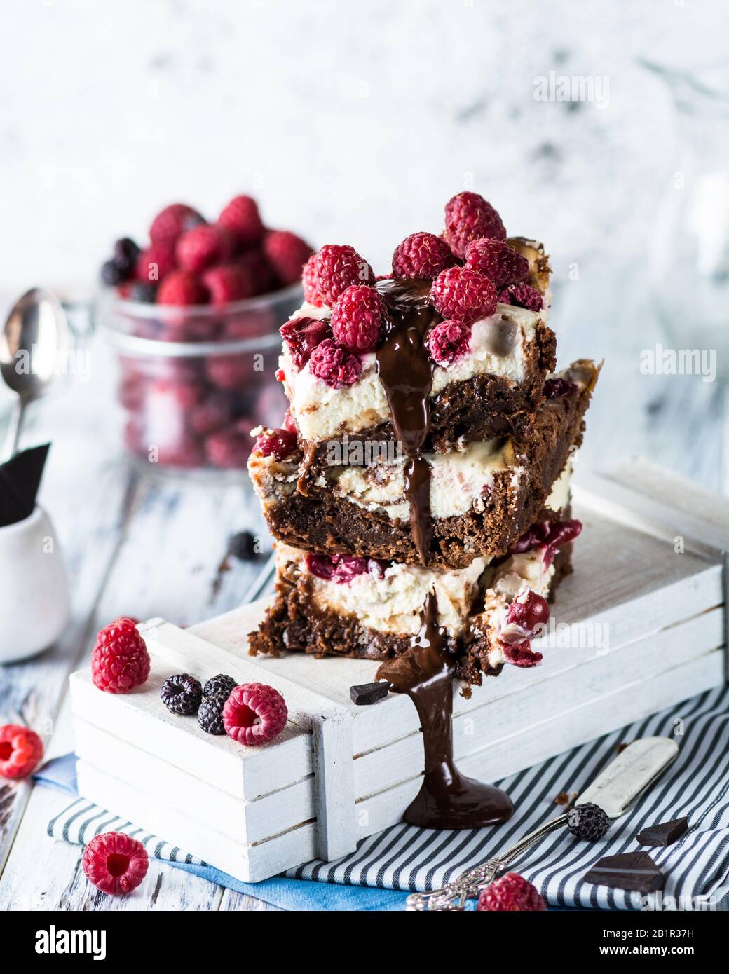 Cheesecake brownies con lampone accatastato su un piatto. Fusione del cioccolato. Pezzo di torta. Dessert brownie. Ciliegia e lampone. San Valentino. Foto Stock