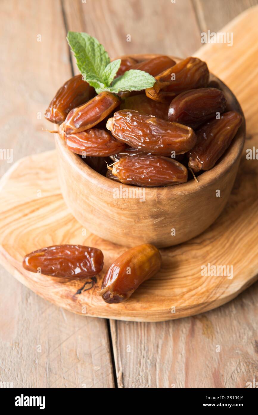 Datteri frutta di palma in ciotola di legno è spuntino sano. Foto Stock