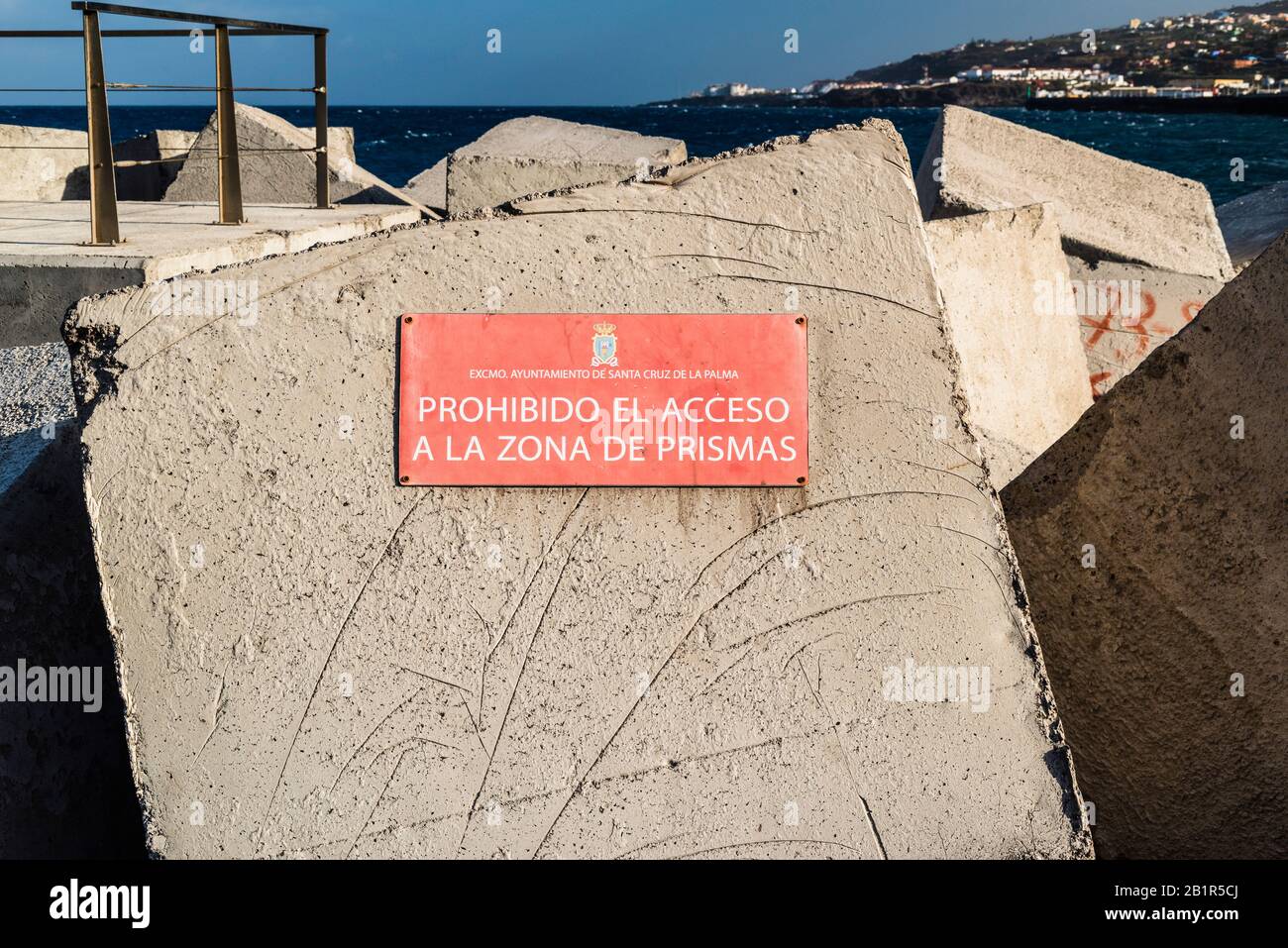 Grandi blocchi di cemento per la difesa costiera al porto di Santa Cruz de la Palma con segnale di avvertimento per non entrare nella zona dei blocchi Foto Stock