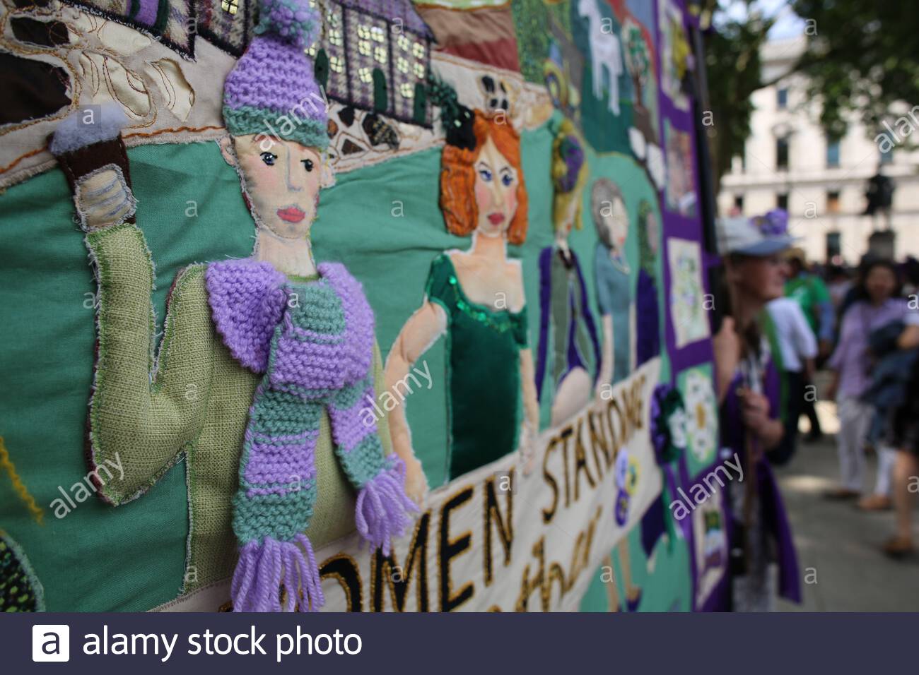 Un banner con le parole Donne in piedi insieme a Wwestminster fatto da donne che hanno partecipato al corteo di 100 anni di suffragio. Foto Stock