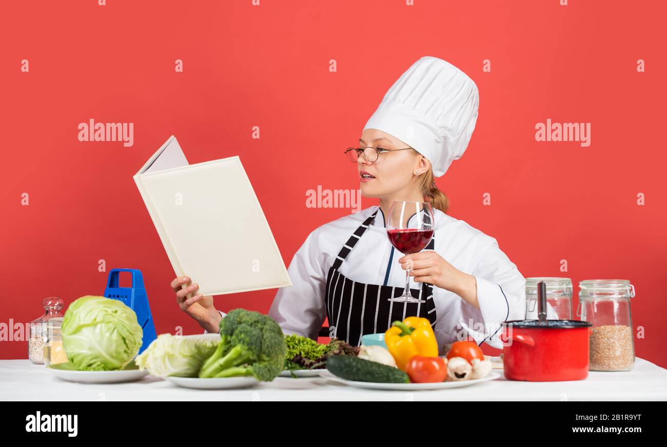 pratica di più. chef professionista leggere la ricetta per cucinare. chef femminile preparare il piatto. cucinare nella sua cucina. Apri il ricettario per una cucina sana. Mantiene un segreto sugli ingredienti. Donna utilizza Cookbook. Foto Stock