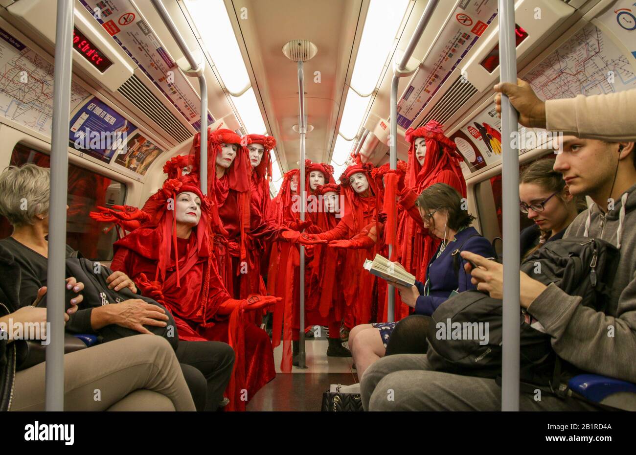 @ptrbrks 'Etiquette'. La Brigata Red Rebel è una protesta di performance, che proietta emozioni per interrompere la vita quotidiana e chiedere un’azione climatica. Foto Stock