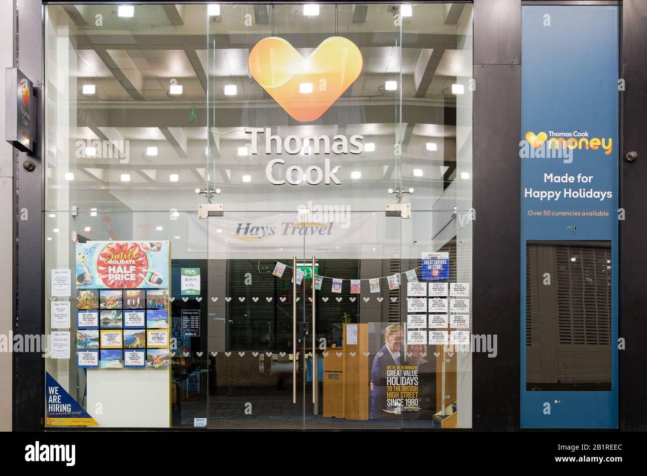 Ex Thomas Cook che prende il controllo da Hays Ufficio viaggi. Vetrina facciata con offerte di viaggio e poster con logo della vecchia e nuova società di OPA a Manchester. Foto Stock